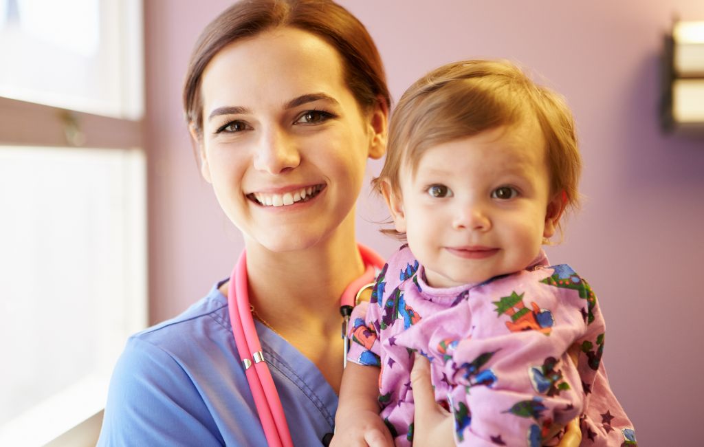 A nurse holds a little girl, representing pediatric home health.