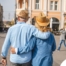 2 older adults hug while on vacation representing the successful outing that can still happen while caring for elderly loved ones.