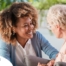 A caregiver warmly speaks with an older client, representing the quality communication that can come with bilingual care.