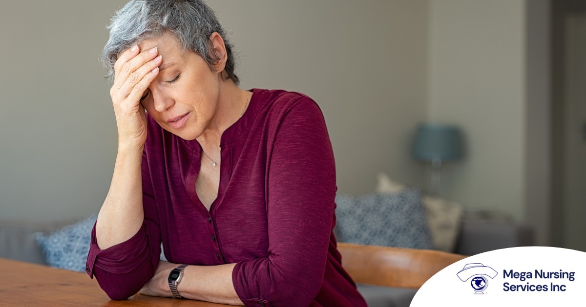 A woman holds her head in her hand, representing the stress that new family caregivers go through.