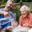 A caregiver applies summer Caregiving Tips including helping a senior stay hydrated.