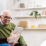 Home caregiver assisting senior man to use telehealth and senior care